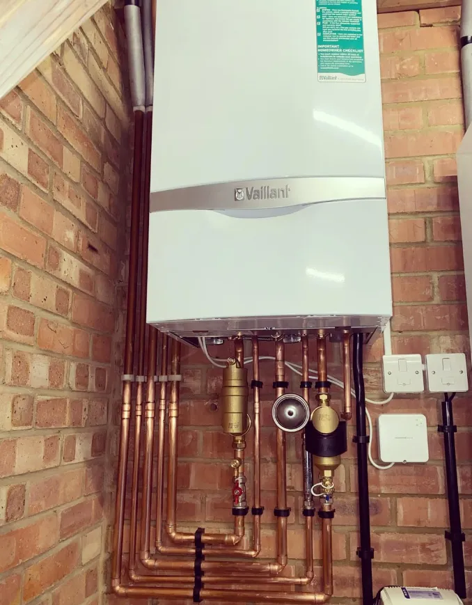 Vaillant boiler with neat copper pipework on a brick wall