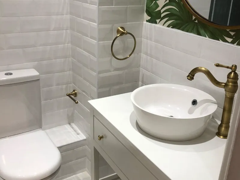 Bathroom with brushed brass tap and white vessel basin