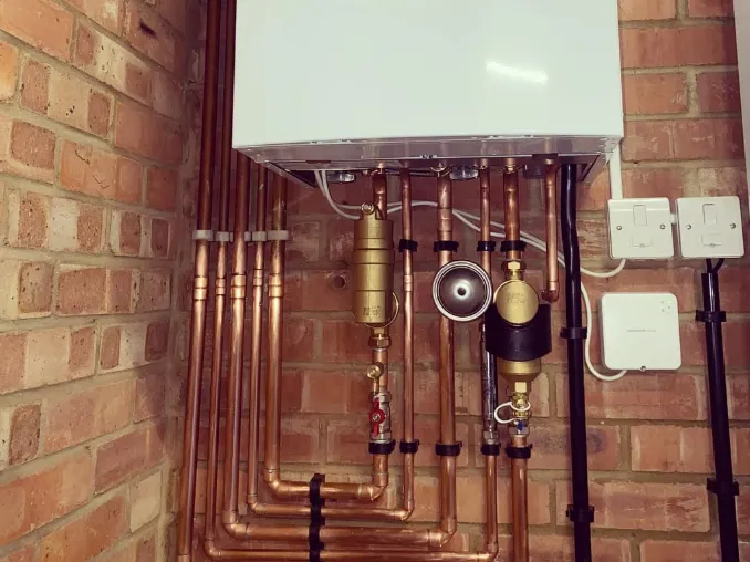Vaillant boiler with copper pipework on a brick wall
