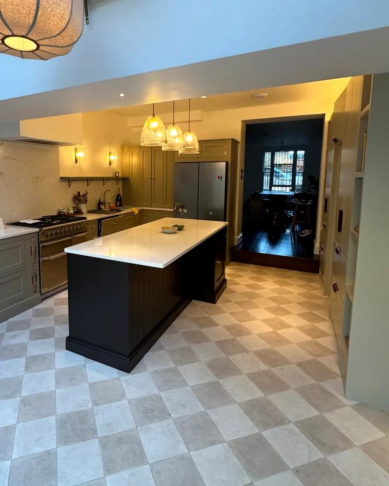 Finished kitchen with sage green cabinets, a dark island and a range cooker